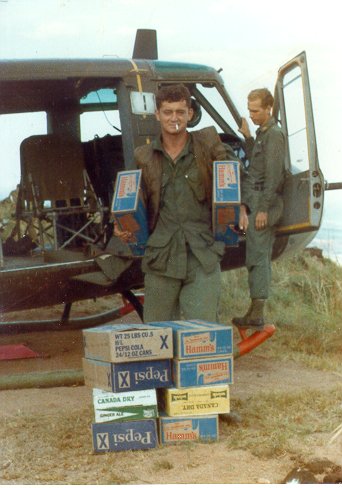 Charles McLaughlin was door gunner, who started his tour of duty in 1966.  Delivery of a precious cargo of Pepsi and ...uh Hamms beer.  I believe the pilot in the background  is Michael Manning... can anyone confirm? 